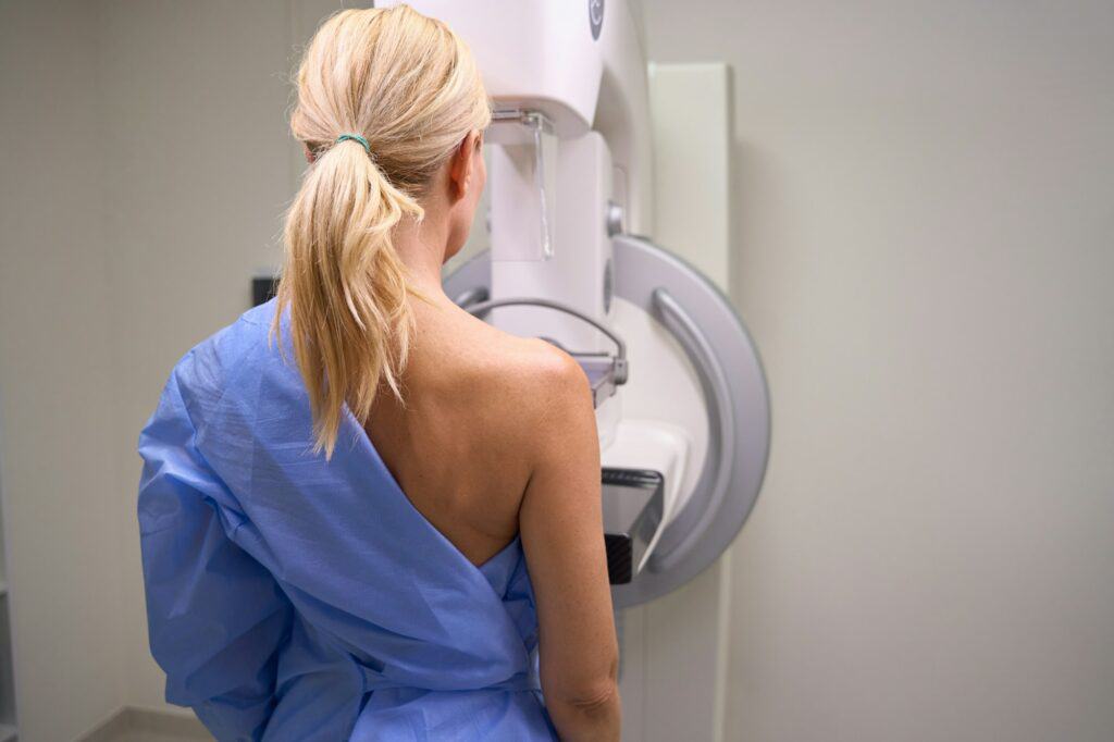 Adult Caucasian woman undergoing screening mammogram in clinic