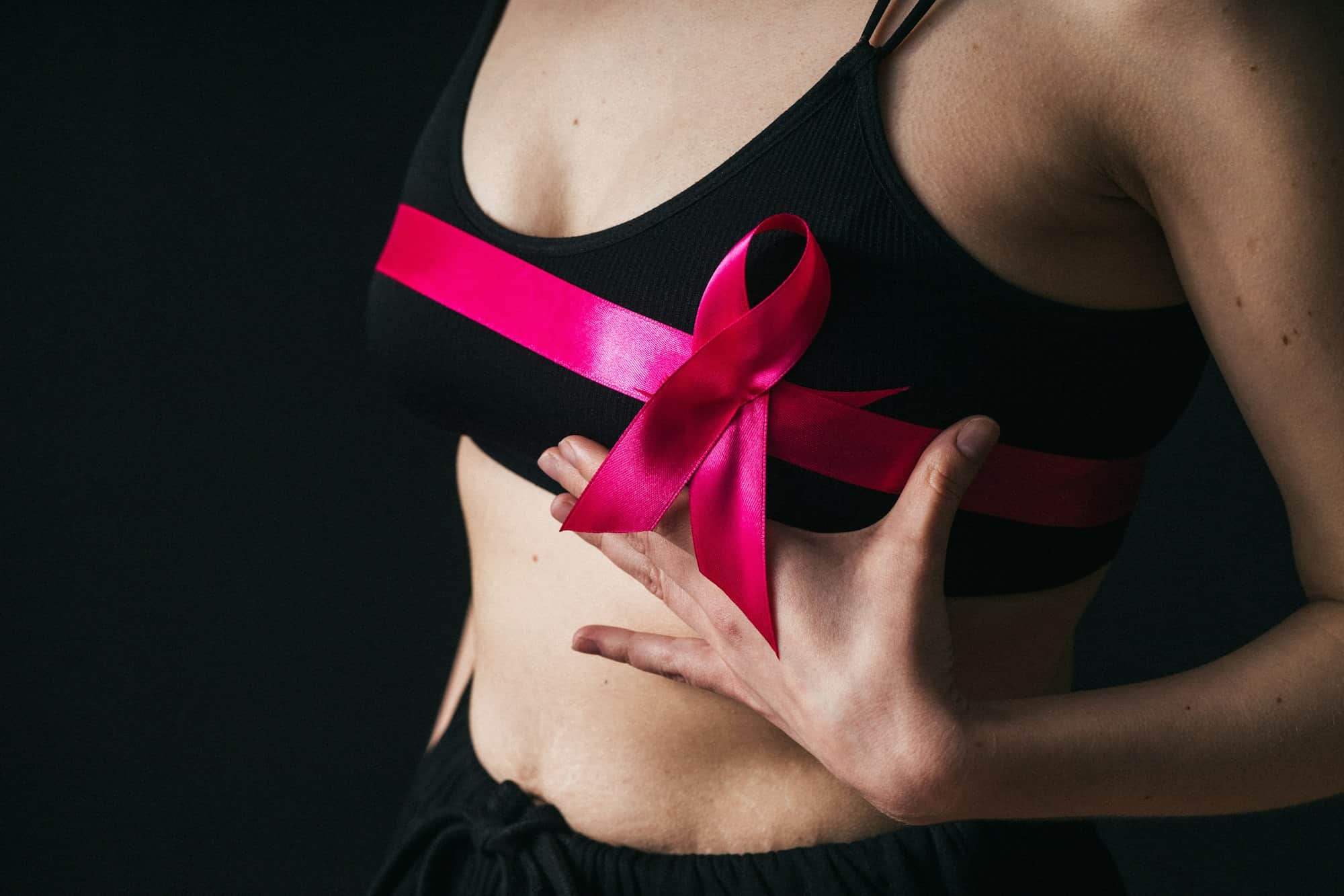 Healthcare and medicine - woman with pink breast cancer awareness ribbon. World Breast Cancer Day.