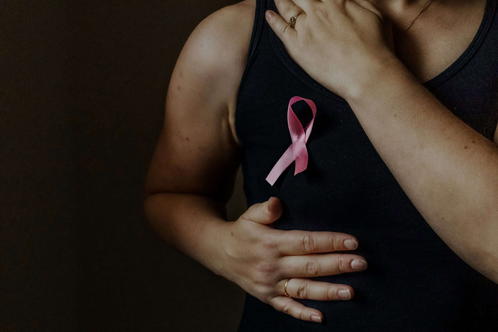 October is breast cancer awareness month, a woman holds a pink ribbon to support people sick.