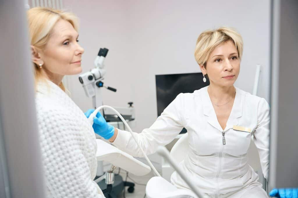 Photo of female gynecologist who conducts breast examination using ultrasound