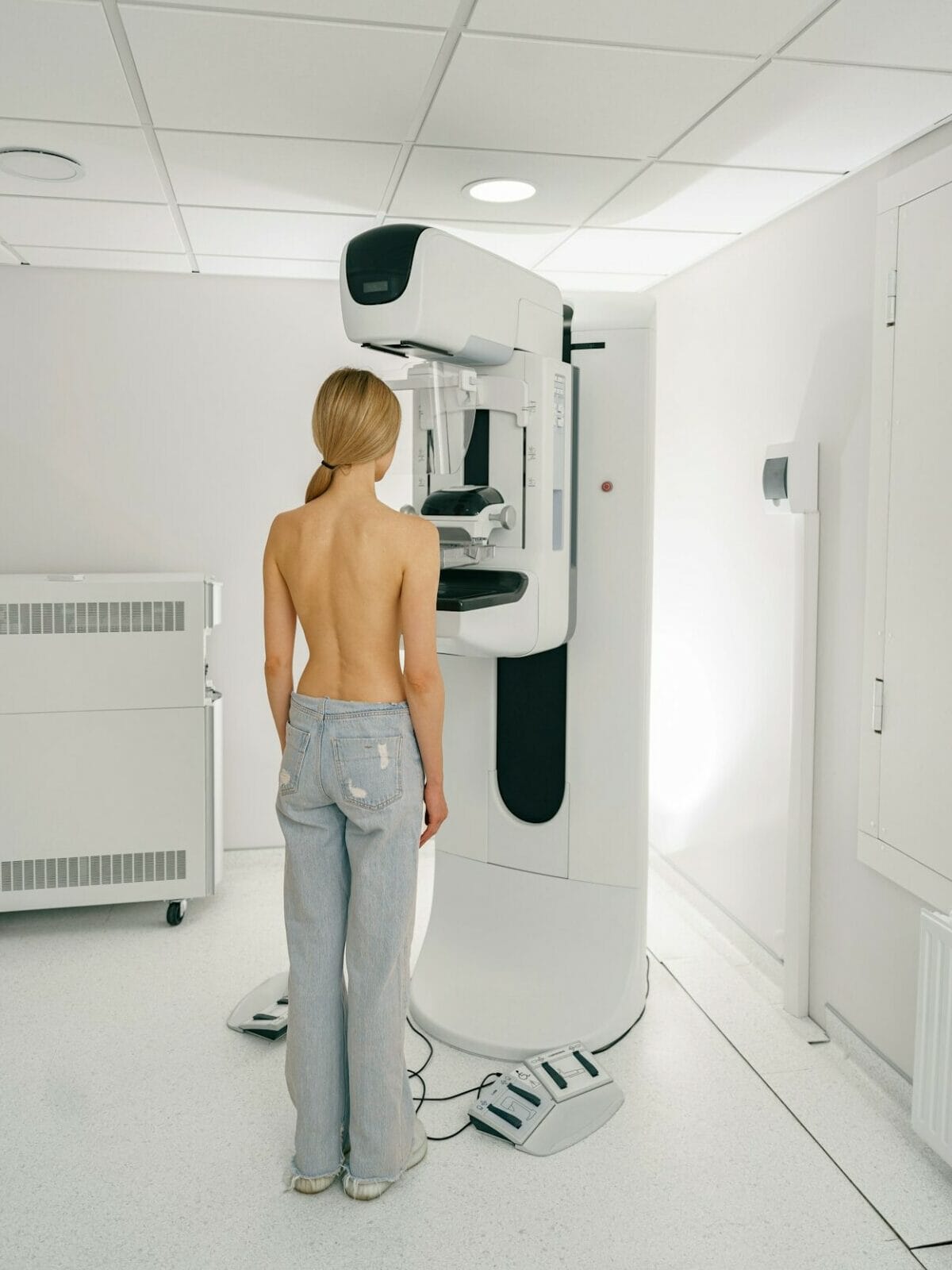 Young woman doing mammogram x ray for breast cancer prevention screening at modern hospital